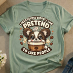 Green t-shirt with cartoon dog in coffee cup saying "I need coffee before I can pretend to like people".