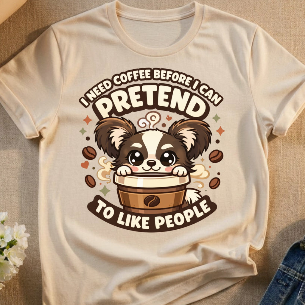 T-shirt with a cartoon dog holding a coffee cup and the text "I need coffee before I can pretend to like people".