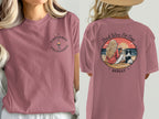 Woman wearing t-shirt with wine and dog graphic on back.
