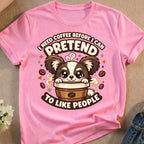 Pink t-shirt with a cartoon dog holding a coffee cup, text reads "I need coffee before I can pretend to like people".